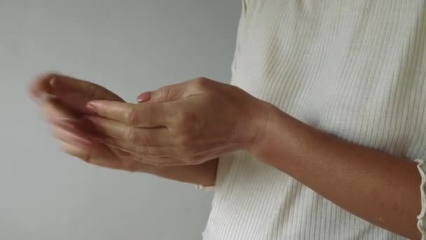 Frau cremt ihre Hände ein. Häusliche Handpflege. Körperpflege am Morgen. Handmassage, Entspannung — Stockvideo