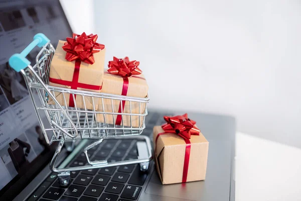 The concept online shopping. Laptop and small shopping cart. Christmas Sales. Fast delivery. Gifts when ordering