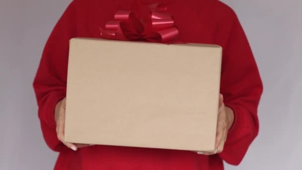 Подарунки в жіночих руках. Експрес доставка. Молода жінка в червоній сорочці тримає картонні коробки з червоним бантом. Інтернет-магазин Продаж. Карантин. Онлайн доставка — стокове відео