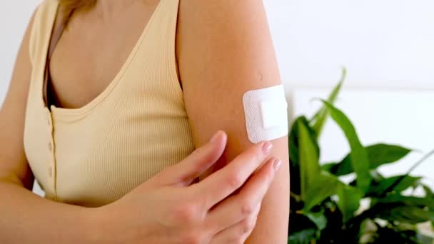 Il primo piano di una giovane donna rimuove un cerotto dopo la vaccinazione. Donna che mostra il braccio con gesso dopo la vaccinazione. — Video Stock