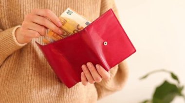 50 Euro 'luk banknotlarla kırmızı deri bir cüzdan tutan kadın ellerini kapatın. Ödeme faturaları, aylık harcamalar, yardım