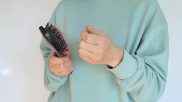 Kobiece ręce czyszczą szczotkę do włosów.Wiele włosów spadło na grzebień. Problem wypadania włosów, niewydolność hormonalna, stres, dieta, choroba głowy i żarówki włosów.Koncepcja wypadania włosów — Wideo stockowe