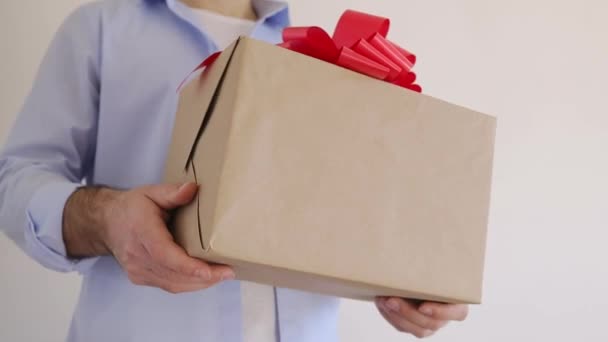 Mans trzyma pudełko prezentów z czerwonym łukiem. Dostawa Express, wyprzedaż świąteczna. Zakupy online. Walentynki — Wideo stockowe