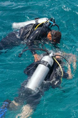 Kızıl Deniz 'in sularında bir eğitmenle tüplü dalışın başlangıcı, ilk ortak dalış, su altında doğru nefes alma eğitimi, tüplü dalış ekipmanları