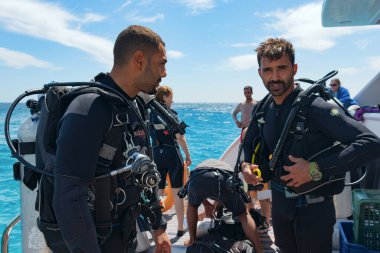 Kızıl Deniz, Hurghada, Mısır, Mart 2021, bir çift dalış eğitmeni tam teçhizat denize dalmadan önce