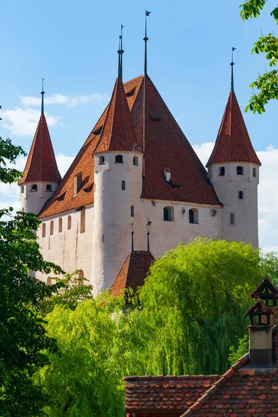 Thun Kalesi 'nin kahverengi kiremitli çatısı olan beyaz binanın panoramik manzarası