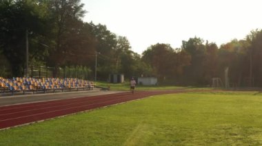 Yazın stadyumda koşan adam.