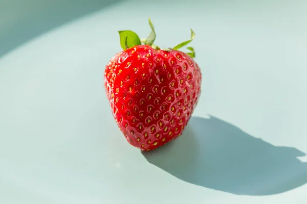 One red strawberry on the green plate. Healthy lifestyle concept. — Stock Photo, Image