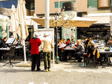 Tel Aviv, İsrail - 4 Şubat 2017: Turistler Tel Baruch plajı yakınlarındaki açık kafede yemek yiyorlar.