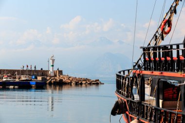 Antalya, Türkiye - 22 Şubat 2019: Antalya 'nın Eski Kenti Kaleici limanındaki deniz fenerinin yakınındaki iskeledeki eski moda turistik yat.