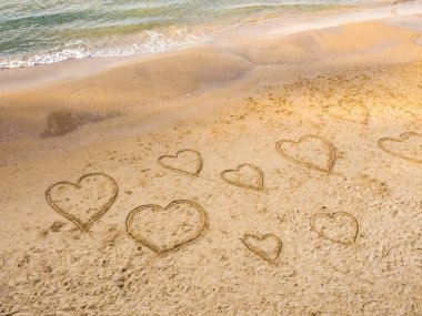 Kalplerin sembolleri Tel Baruch sahilindeki kumlara çiziliyor. Tel Aviv Güvertesi. İsrail