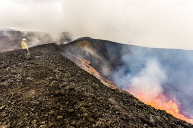 Petropavlovsk-Kamchatsky bölgesi, Rusya - 11 Ağustos 2013: Tolbachik Volkanı 'nın patlama kraterinin kenarında duran turist.