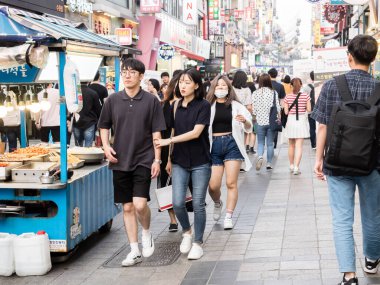 Suwon, Güney Kore - 15 Haziran 2017: Suwon 'da ana caddede yürüyen genç Koreli çift.