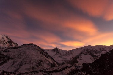 Dağların üzerinde pembe bulutlar. Himalayalar 'da güzel bir gün batımı, Nepal, Tilicho Ana Kampı