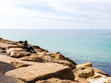 Tel Aviv, İsrail - 4 Şubat 2017: Sahilde dinlenen ve kitap okuyan adam.