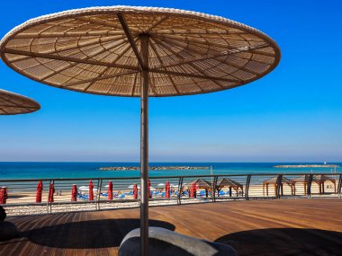 Güneşli yaz gününde, Tel Aviv, İsrail sahilinde saman güneş gözlüğü..