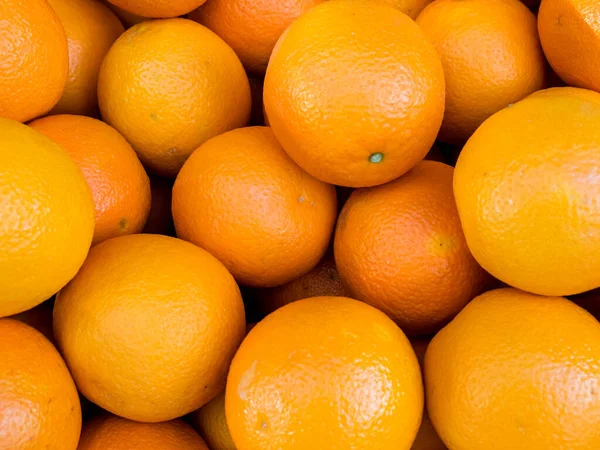 Close up image of juicy organic oranges on the farmers market. Orange background.