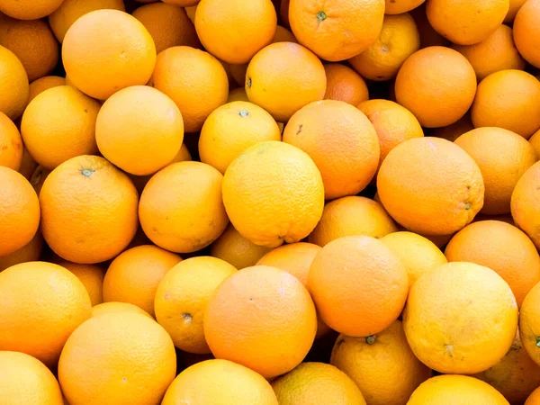 Fresh juicy organic oranges on the farmers market. Close-up orange background.