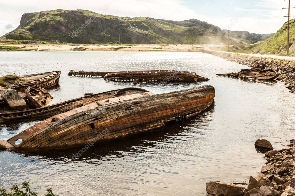 Sunken old wooden fishing boats in Teriberka, Murmansk Oblast, Russia