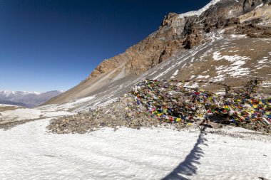 Thorong La Pass dağı (5416 m), Annapurna Trek, Himalayalar. Rüzgarda dalgalanan Budist bayrakları.