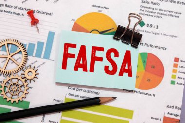 Fafsa kelimesi bir defterde beyaz masada ofis aletleriyle birlikte. İş konsepti
