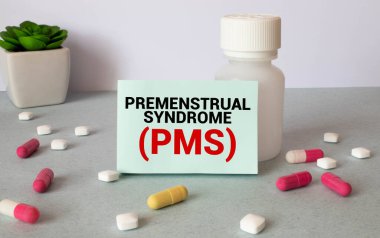 PMS - Premenstrüel sendrom ahşap arka plan üzerinde defterde yazılı.