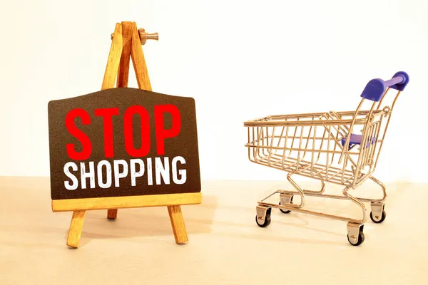 the concept of refusing to buy a reasonable consumption is an inverted shopping basket with a padlock x keys and a sign with the inscription stop shopping. High quality photo
