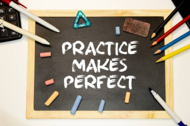 Pratik, siyah tahtada beyaz tebeşirle mükemmel harfler oluşturur..