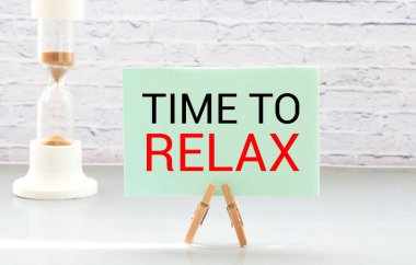 İçinde dinlenme zamanı yazan bir defter var. Yakınlarda kulaklık ve elma var. Arka planda kırmızı ekose ve yeşil çimen var. Tasarım kavramı.