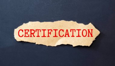 Sayılar ve büyüteçle dolu bir masanın arka planında beyaz bir not defterindeki sözcükler. İş konsepti