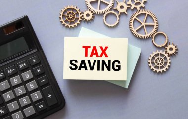 Metin Vergi Tasarruf ile hesap makinesi. Hesap makinesi, para birimi, kitap, fatura ve kalem. İş, finans kavramsal.