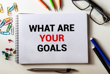 İlham verici bir alıntı. Hedeflerine odaklan. Beyaz kâğıt defter ve kalemlerdeki kısa mesajlarla