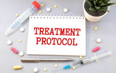 Tedavi protokolü beyaz kağıda steteskop yakınında gri bir arkaplan üzerine yazılmıştır. Tıbbi konsept