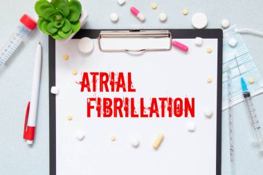 Tıp ve sağlık konsepti. Bir çalar saat, haplar, enjeksiyonlar ve üzerinde Atrial Fibrillation yazan bir kart.