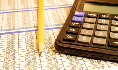 Finansal iş için beyaz kağıda siyah kalemle yakın plan gümüş hesap makinesi hesaplar ve klasik mavi ve sarı tarzda yatırım yapar veya sıcak tonda serinletir