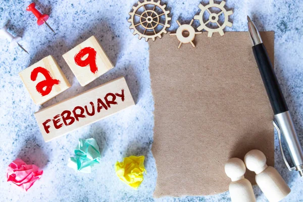 29 de febrero. Fecha del mes de febrero. Número Cubo con una flor y cuaderno en la mesa de madera de diamante para el fondo — Foto de Stock