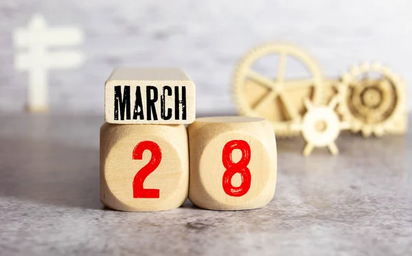 28 de marzo, Cubo de calendario de madera en tela de fieltro amarillo con flor de peonía para el fondo icono de la fecha. — Foto de Stock