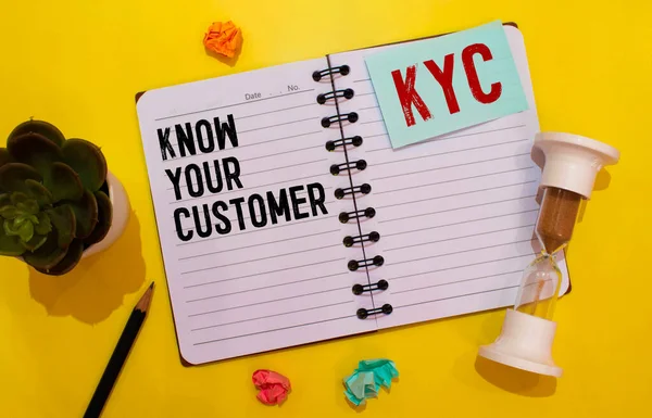 KYC - Conozca las siglas de su cliente, en el bloc de notas y los accesorios de oficina en el escritorio amarillo. — Foto de Stock