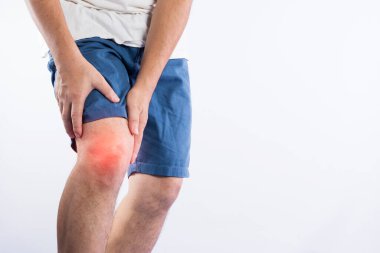 Diz ağrısı olan genç bir adam beyaz bir arka planda izole edilmiş.