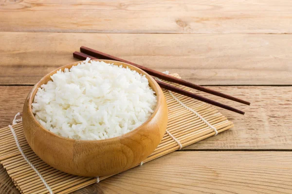 将白米或茉莉花米放在木碗里 将筷子放在木地板上 — 图库照片