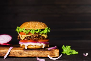 Yakın plan lezzetli ev yapımı hamburgerler ahşap bir masanın üzerinde koyu arkaplanlı sığır etli hamburger taze pişmiş lezzetli