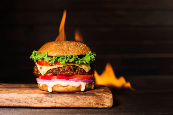 Leckerer Hamburger Mit Flamme Auf Dunklem Hintergrund — Stockfoto