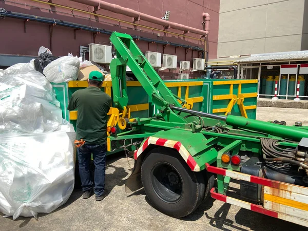 配备绿色卡车运送垃圾的员工 城市废物回收服务 — 图库照片