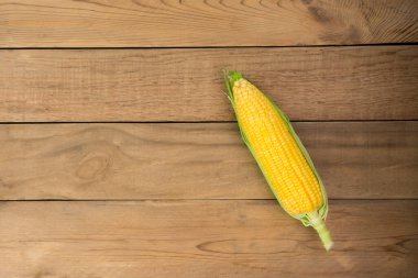 Fotokopi alanı olan ahşap bir masanın üzerindeki koçanda taze mısır.