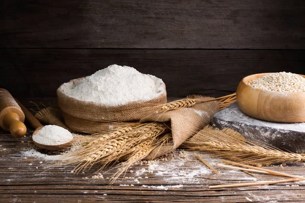 Organic Natural Whole Grain Flour in Sacks and wheat seeds Ears of wheat on an old wooden floor