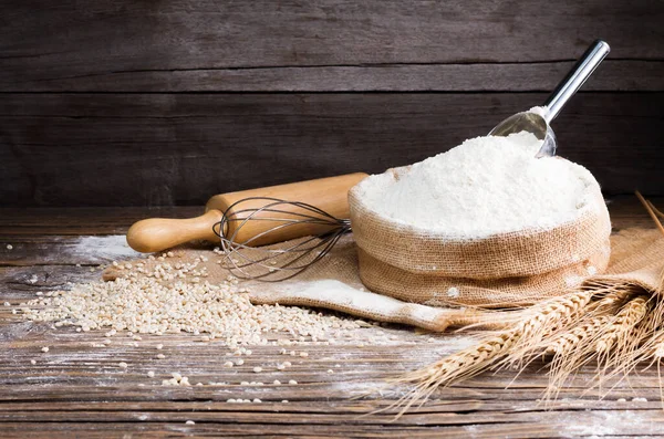 Organic Natural Whole Grain Flour in Sacks and wheat seeds Ears of wheat on an old wooden floor