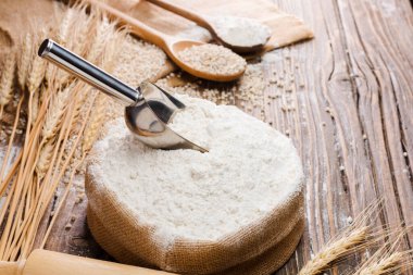 Organik Doğal Kepçe unu Torbalarda ve buğday tohumları Eski ahşap zeminde buğday kulakları