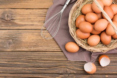 Sepetteki tavuk yumurtaları. Çiftlik taze organik yumurtalar. Kırsal ahşap bir masanın üzerine bırakılmış..