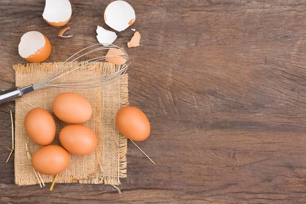 Farm fresh organic eggs laid on a rustic wooden table, top view.