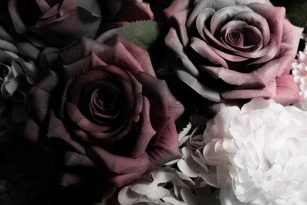 Sahte çiçekler ya da koyu arkaplanda güzel tekstil çiçekleri.